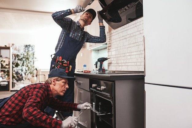 collaboration-work-photo-two-mechanics-working-kitchen_386167-2376